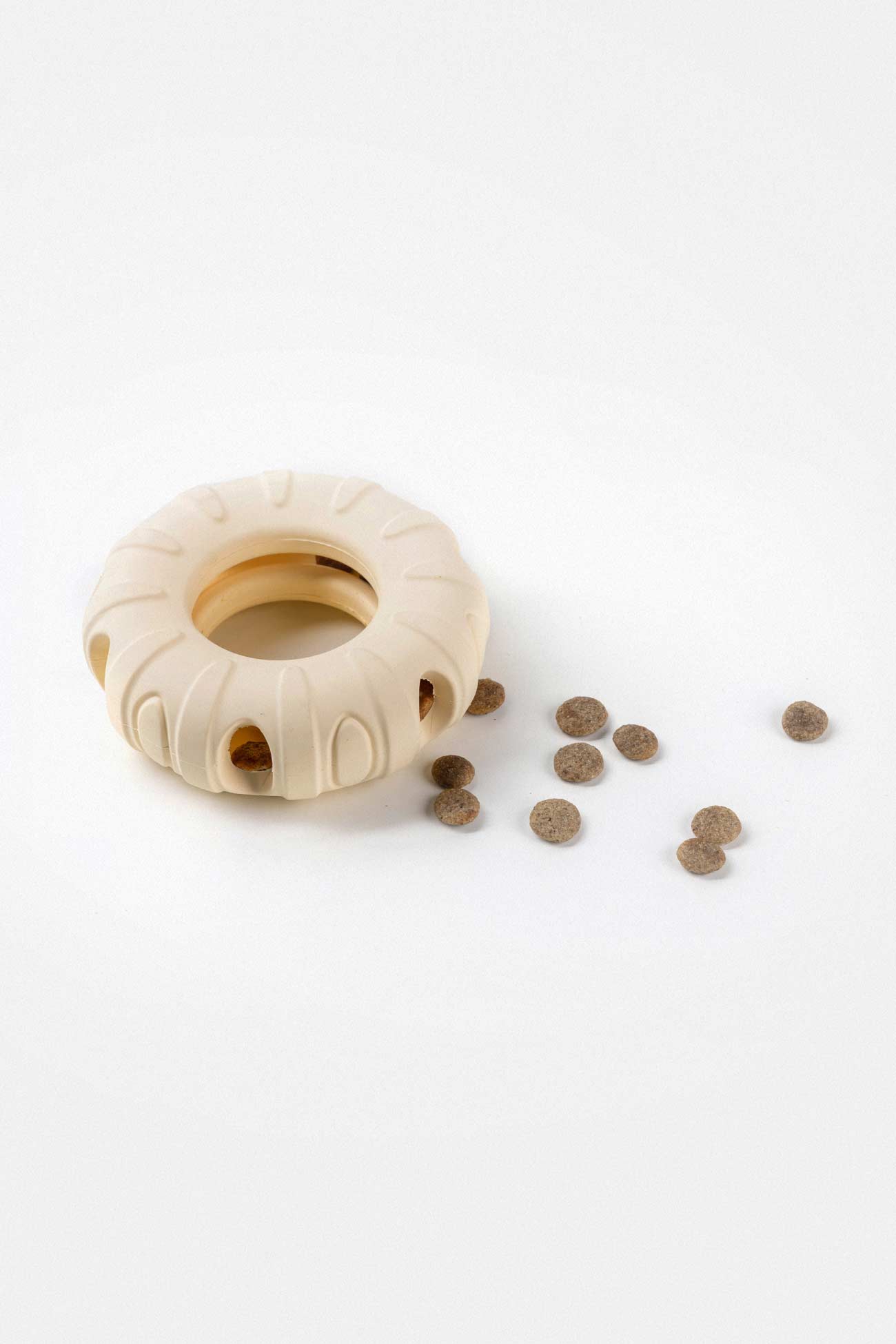 Natural Rubber Chew Ring with dog kibble inside the pet toy coming out.