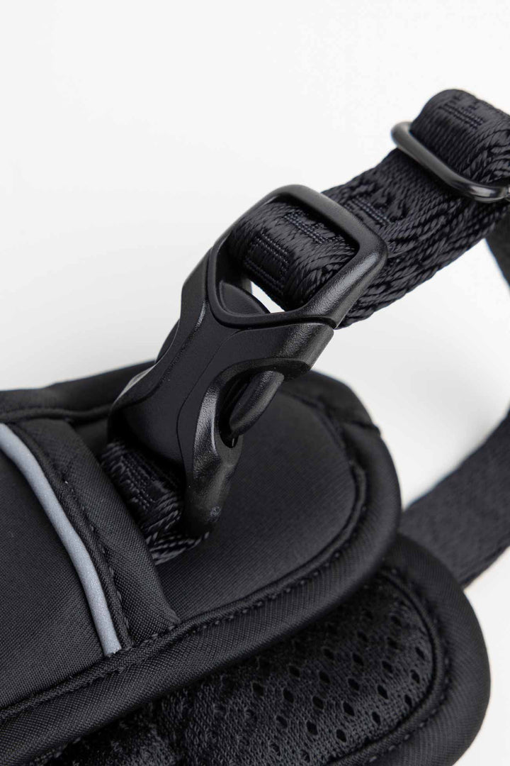 Black dog harness and close-up of the traditional buckle on a white background.
