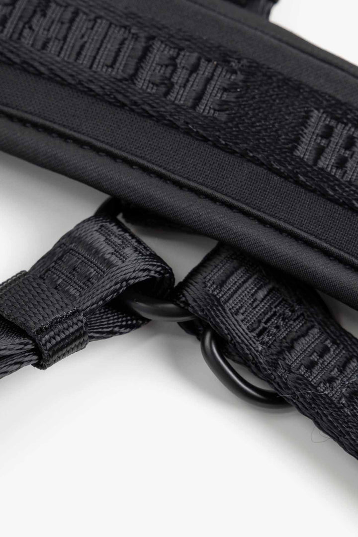 Black Moxie Harness close-up of black tactical straps with visible branding on a white background
